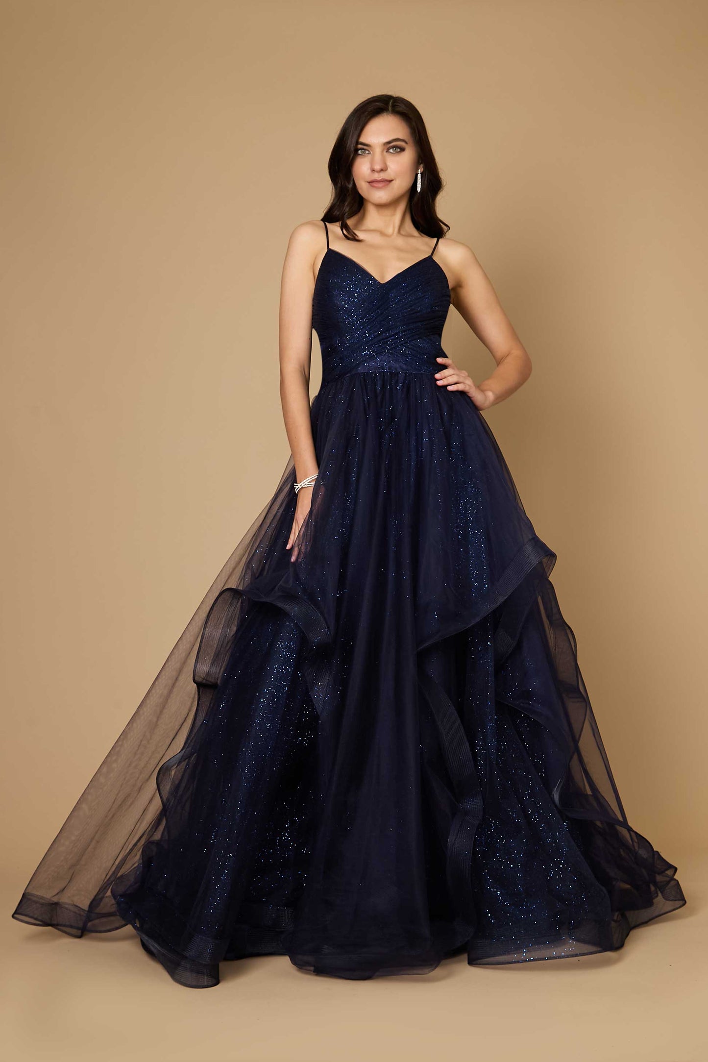 A stunning navy blue long formal ball gown adorned with sparkling embellishments, elegantly flowing to the floor, perfect for a glamorous evening event.