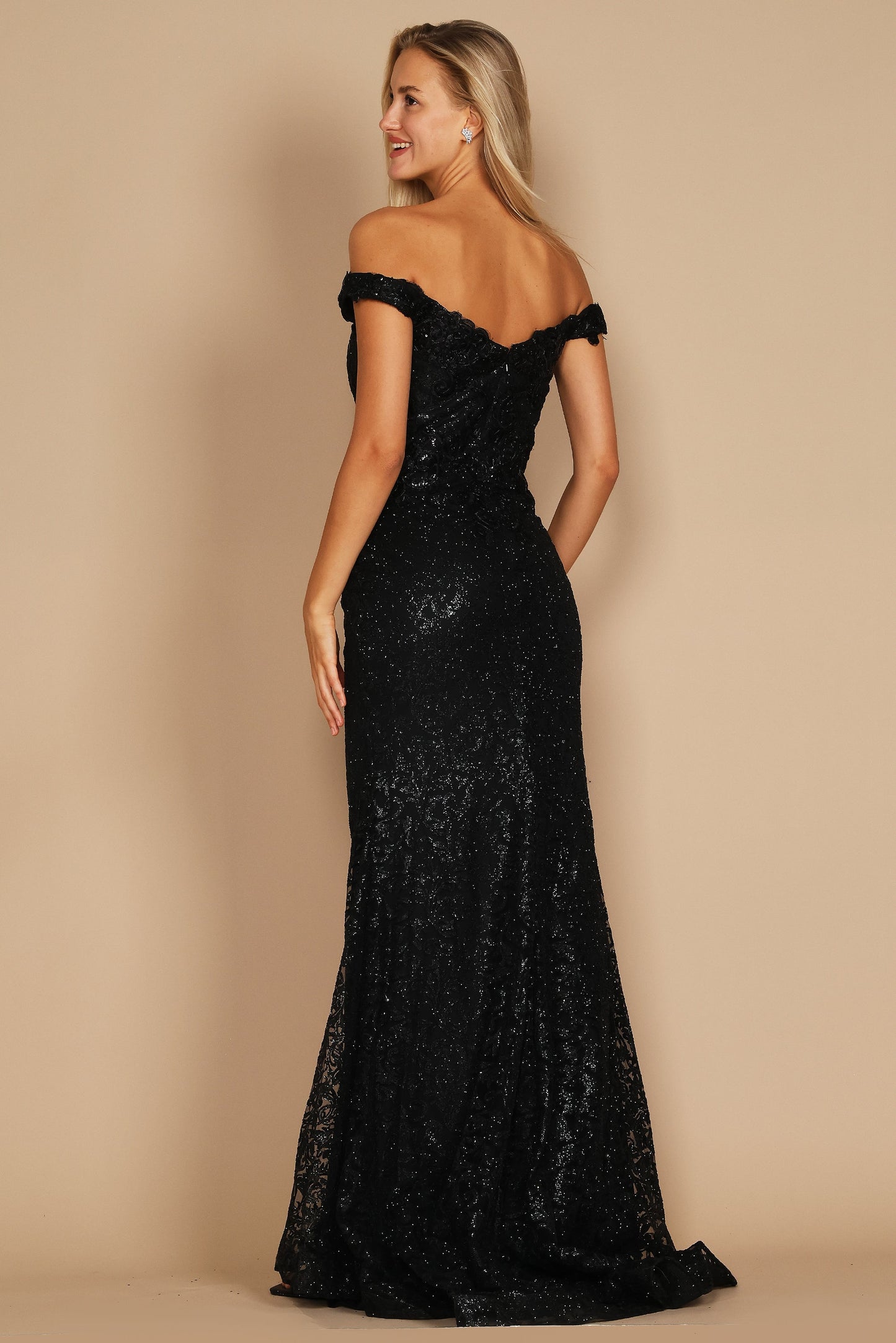 A sleek black mermaid fitted evening dress elegantly hugs the silhouette, featuring a sophisticated neckline and a dramatic flared hem that cascades to the floor.