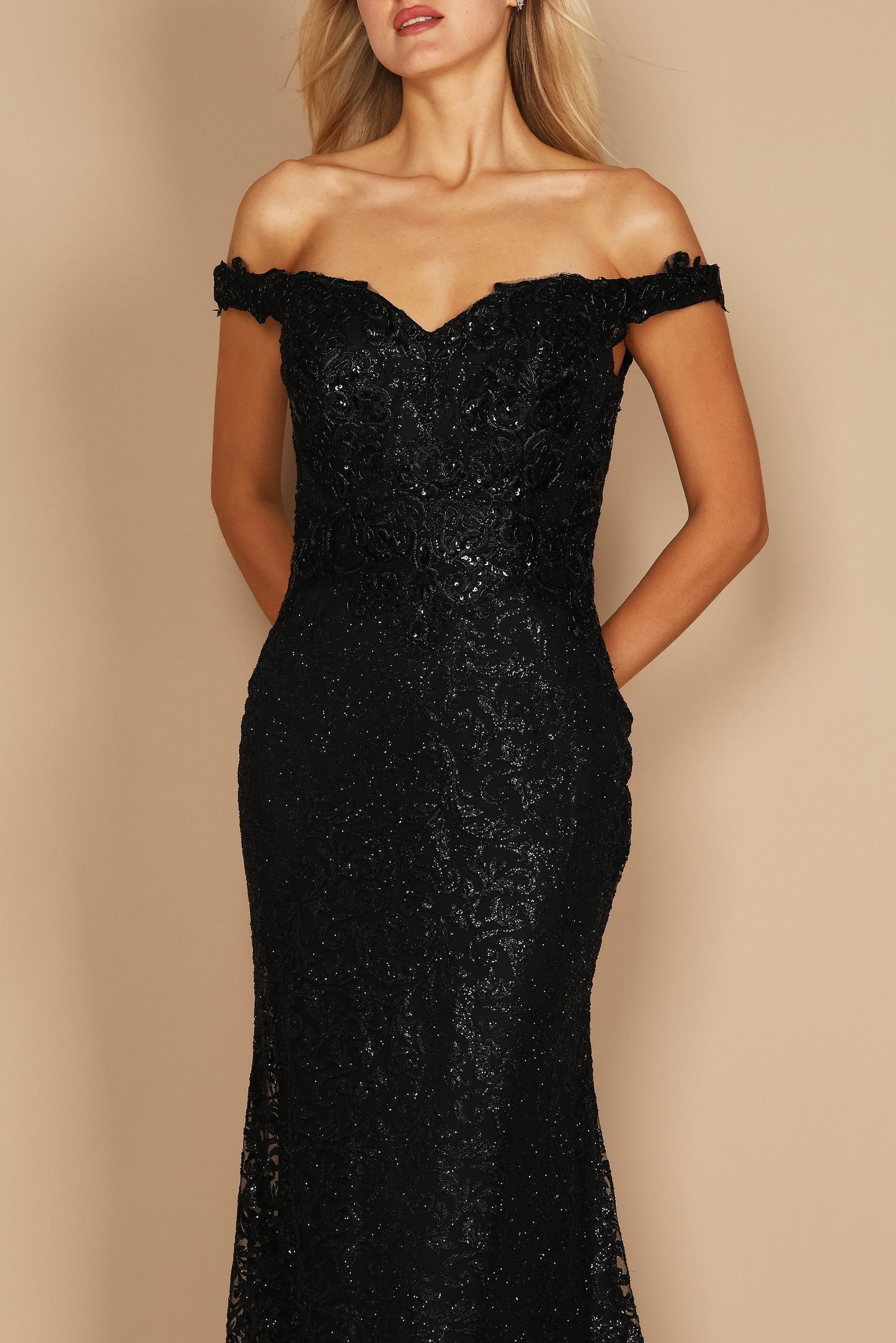 A sleek black mermaid fitted evening dress elegantly hugs the silhouette, featuring a sophisticated neckline and a dramatic flared hem that cascades to the floor.