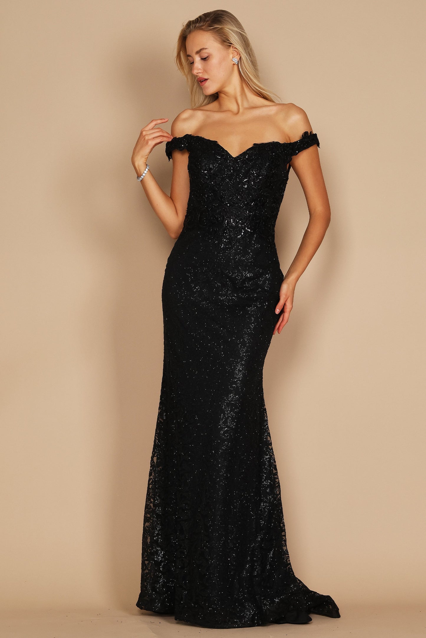 A sleek black mermaid fitted evening dress elegantly hugs the silhouette, featuring a sophisticated neckline and a dramatic flared hem that cascades to the floor.