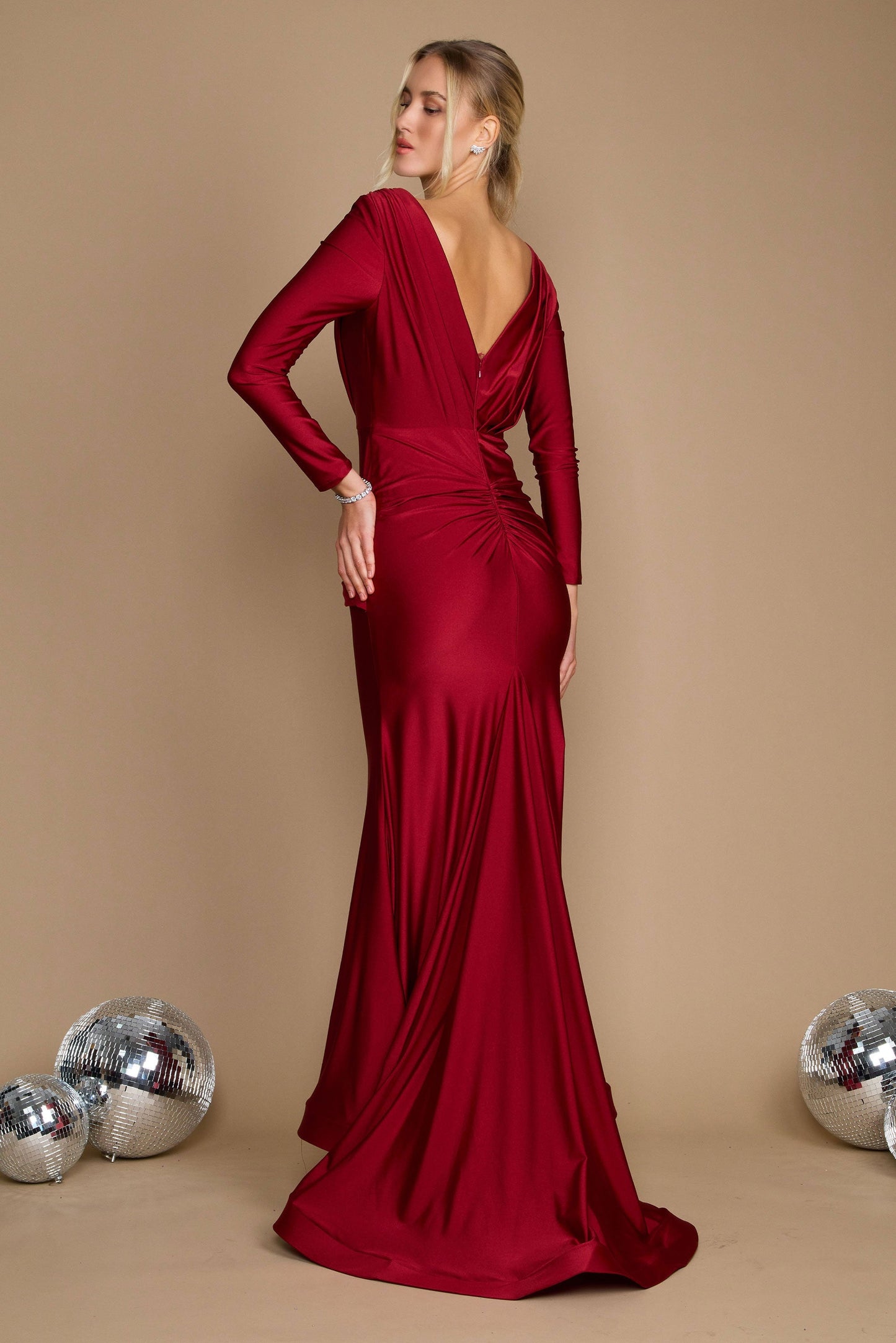 A stunning burgundy long sleeve formal fitted evening dress, elegantly tailored to accentuate the silhouette, featuring a sophisticated neckline and flowing fabric that cascades gracefully to the floor.