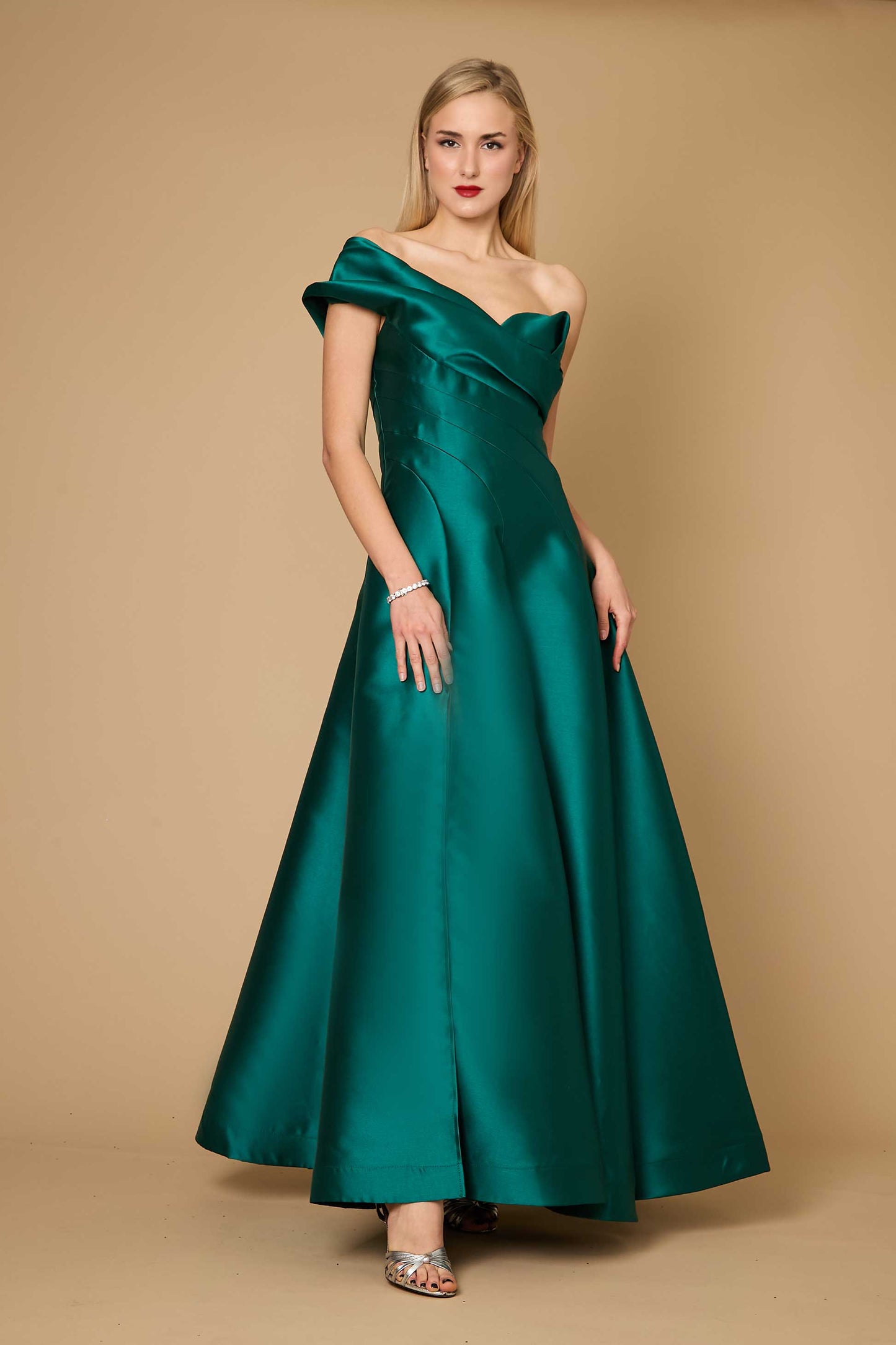 A stunning emerald green one-shoulder long formal ball gown, elegantly draping to the floor, perfect for evening events.