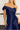 A stunning one-shoulder long formal ball gown in a rich French navy color, elegantly draping to the floor with a flowing silhouette, perfect for evening events.