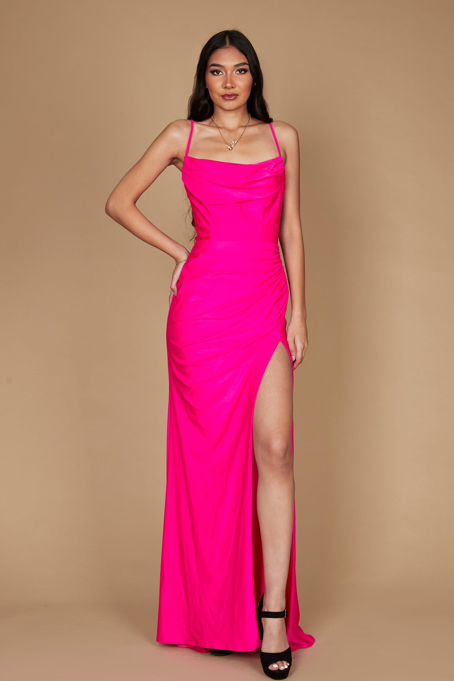 A stunning long formal low back prom dress in vibrant fuchsia, featuring a sleek silhouette that elegantly flows to the floor, showcasing a sophisticated design perfect for special occasions.