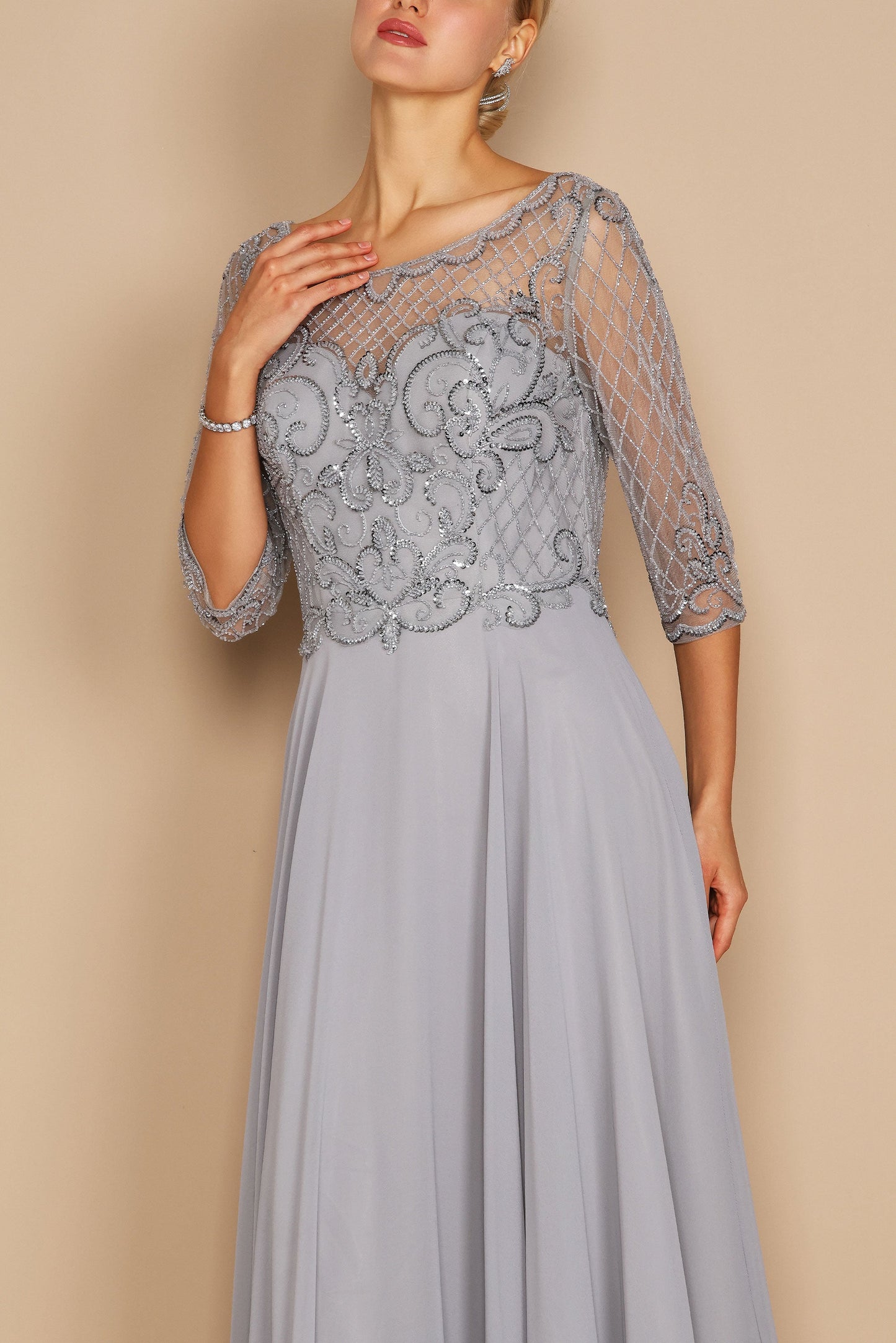 Elegant long sleeve mother of the bride dress adorned with intricate hand-beaded details in shimmering silver, showcasing a sophisticated silhouette perfect for a wedding celebration.